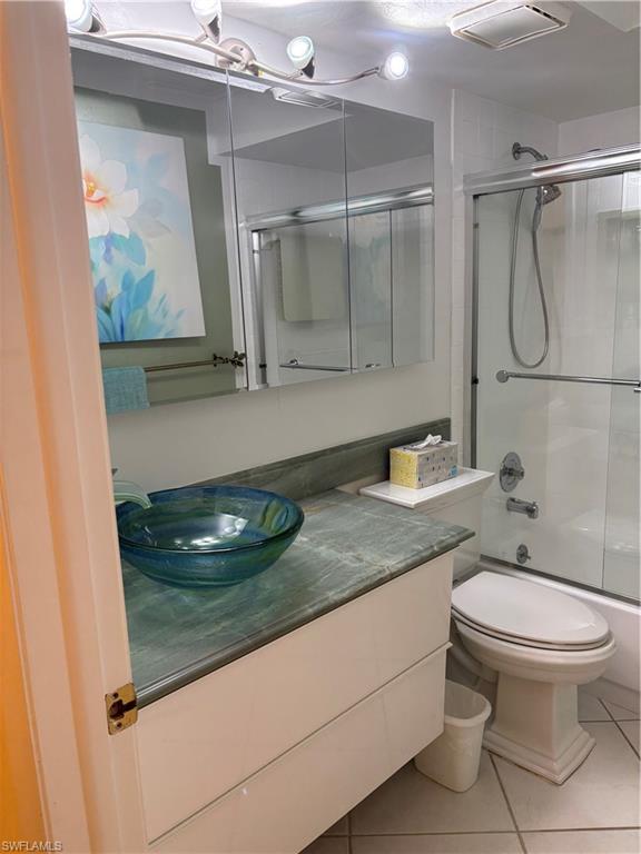 Undisclosed Address Naples, FL 34112 - Photo 21 of 35 Bathroom with toilet, shower / bath combination with glass door, tile patterned floors, visible vents, and vanity
