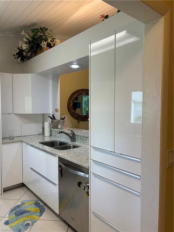 Undisclosed Address Naples, FL 34112 - Photo 4 of 35 Kitchen featuring dishwashing machine, a sink, white cabinetry, wooden ceiling, and light tile patterned flooring