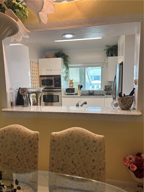 Undisclosed Address Naples, FL 34112 - Photo 5 of 35 Kitchen with fridge, a sink, oven, a toaster, and white cabinetry