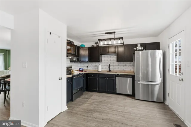 a kitchen with stainless steel appliances granite countertop a refrigerator a stove a sink and a microwave