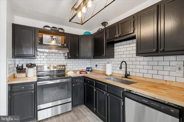 a kitchen with stainless steel appliances a sink stove and cabinets