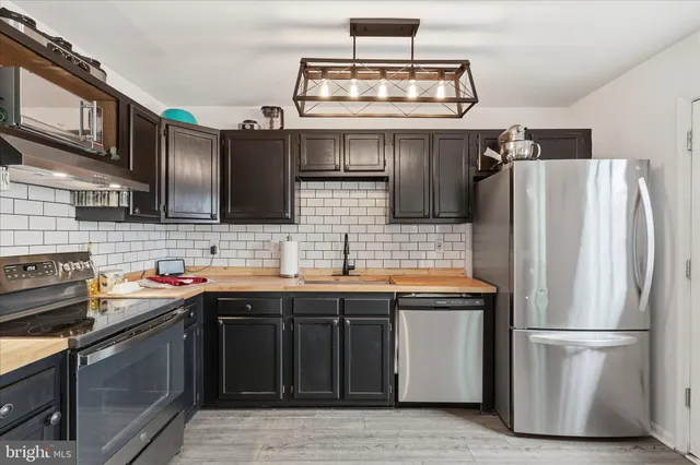 a kitchen with stainless steel appliances a sink stove and refrigerator