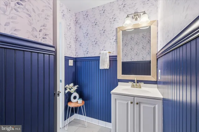 a bathroom with a sink a mirror and a painting on the wall