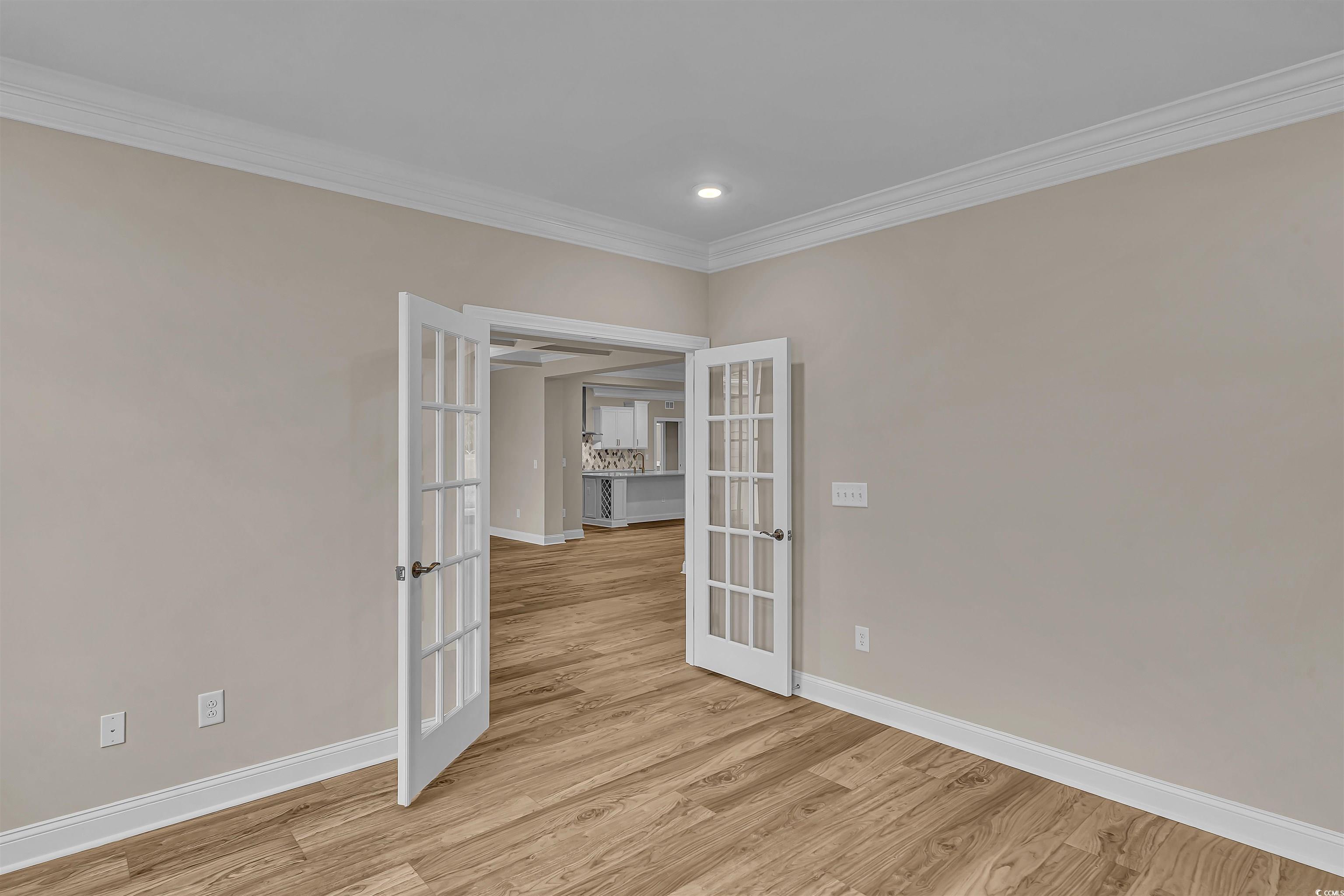 550 Beachside Circle Calabash, NC 28467 - Photo 13 of 39 Unfurnished room featuring light hardwood / wood-style flooring, ornamental molding, and french doors