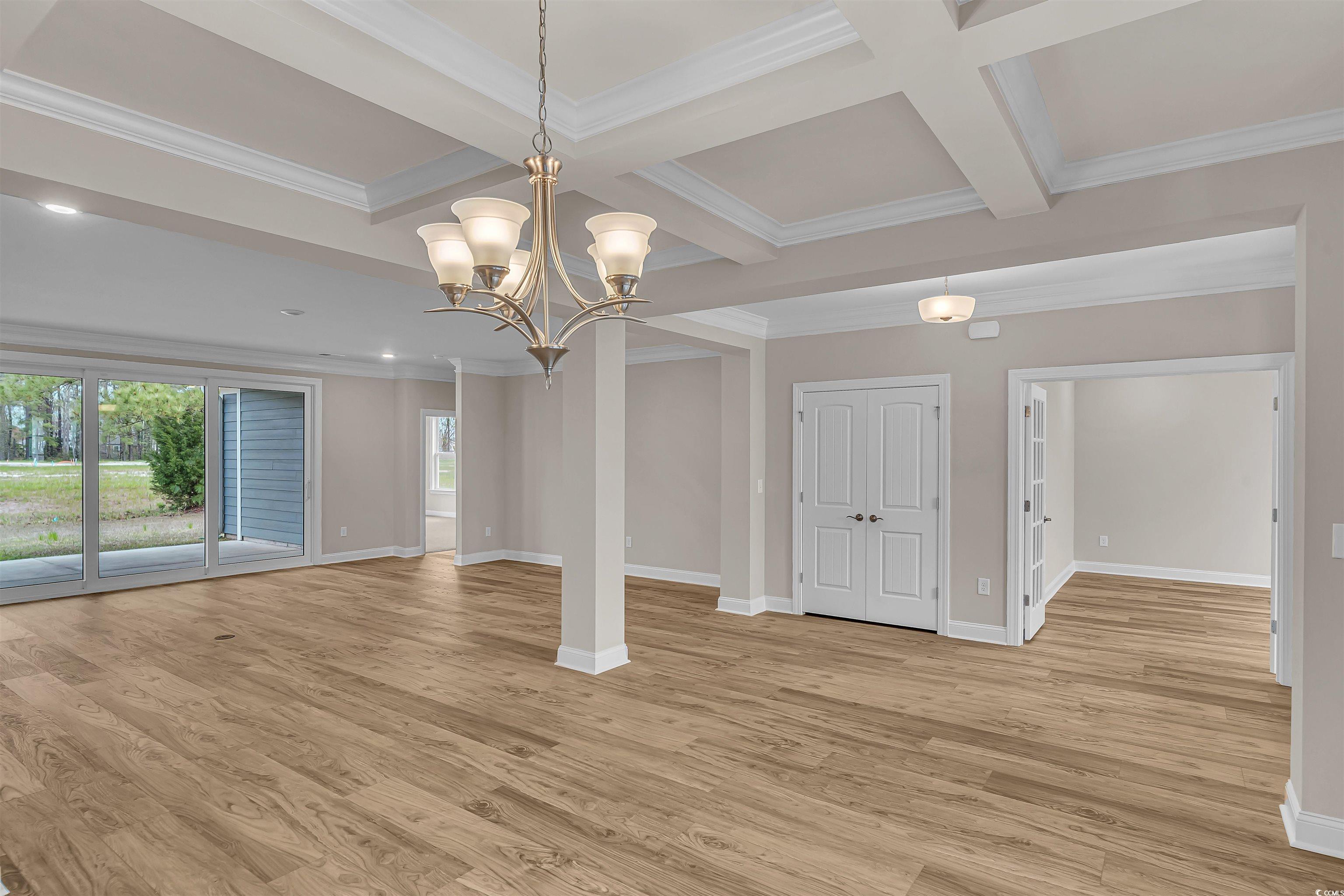 550 Beachside Circle Calabash, NC 28467 - Photo 15 of 39 Empty room with beam ceiling, crown molding, light hardwood / wood-style flooring, and coffered ceiling