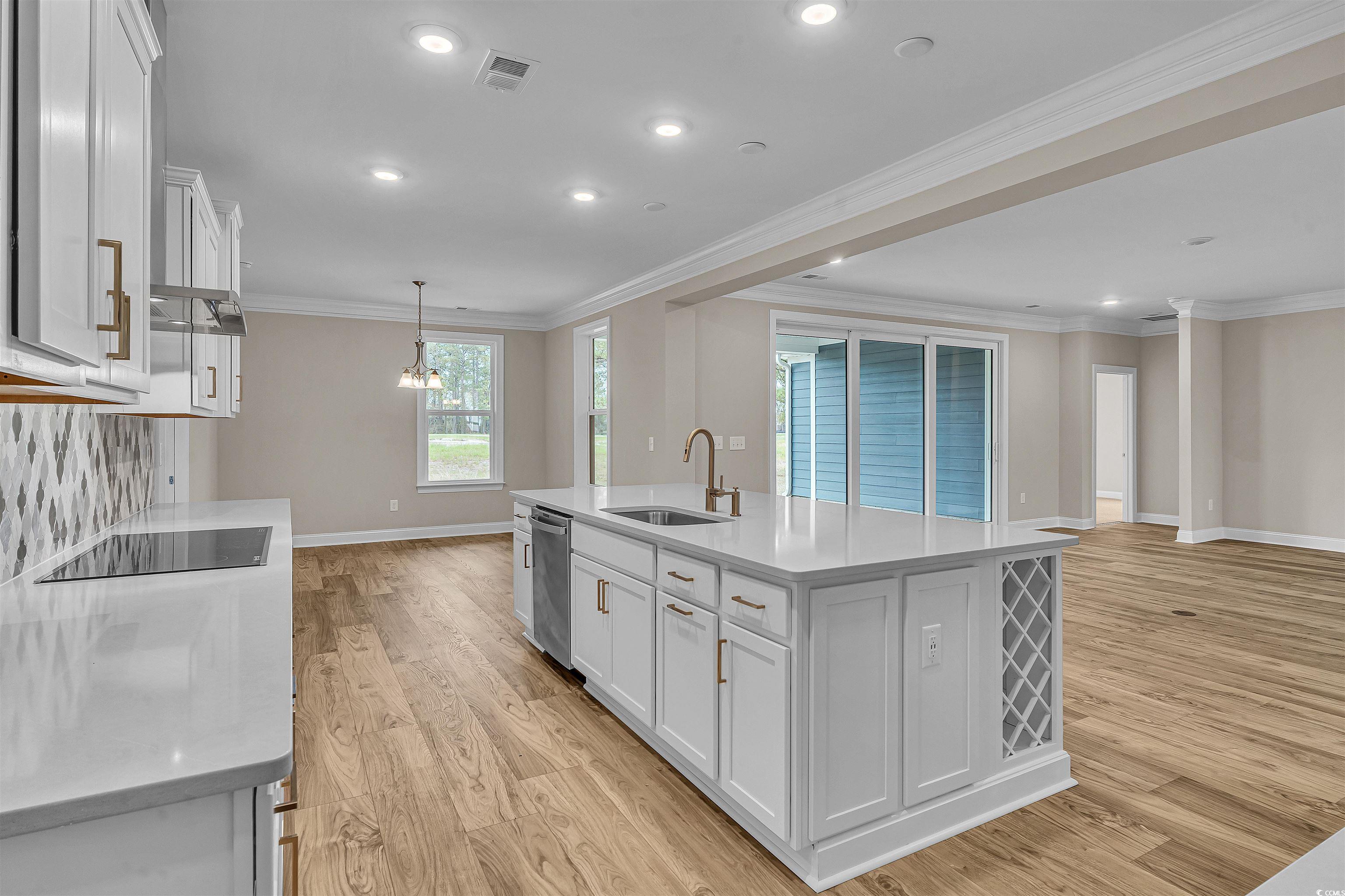 550 Beachside Circle Calabash, NC 28467 - Photo 21 of 39 Kitchen featuring white cabinets, dishwasher, sink, and a kitchen island with sink