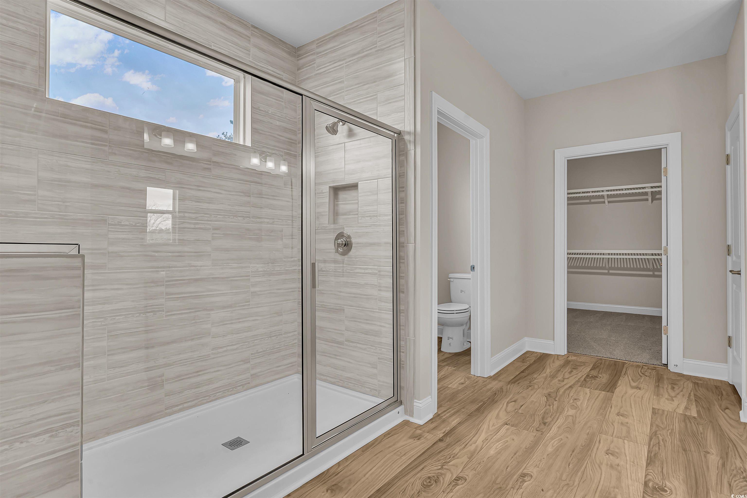550 Beachside Circle Calabash, NC 28467 - Photo 26 of 39 Bathroom featuring wood-type flooring, toilet, and an enclosed shower