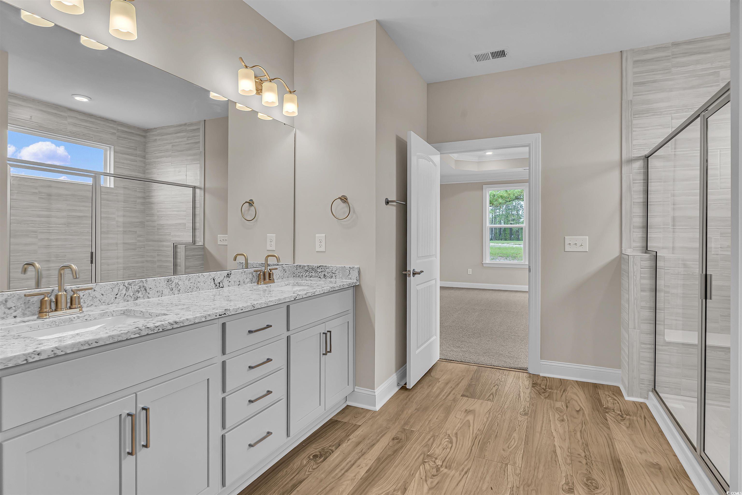 550 Beachside Circle Calabash, NC 28467 - Photo 27 of 39 Bathroom featuring hardwood / wood-style floors, vanity, and walk in shower