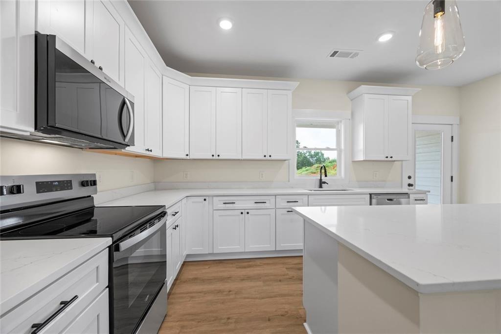 711 Racetrack Road Toccoa, GA 30577 - Photo 3 of 8 a kitchen with cabinets appliances a sink and a window