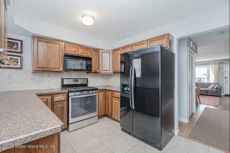 225 Colony Avenue Staten Island, NY 10306 - Photo 7 of 20 a kitchen with stainless steel appliances granite countertop a refrigerator and a stove top oven