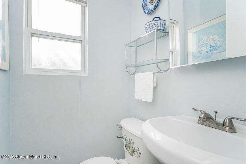 225 Colony Avenue Staten Island, NY 10306 - Photo 8 of 20 a bathroom with a sink a toilet and mirror
