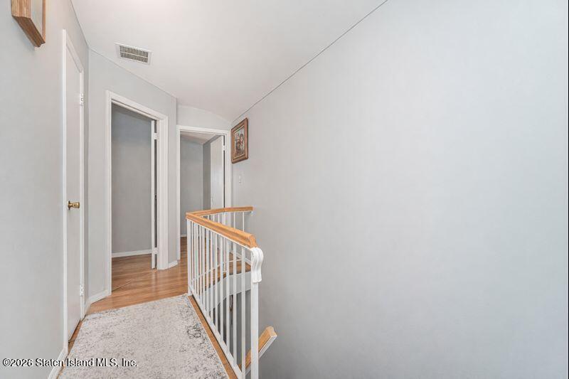 225 Colony Avenue Staten Island, NY 10306 - Photo 9 of 20 a view of a hallway with wooden floor and stairs