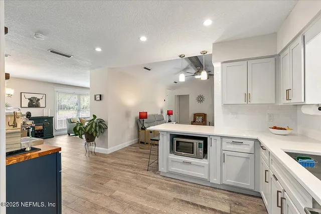 a kitchen with kitchen island white cabinets and stainless steel appliances