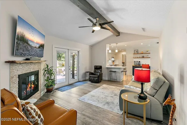 a living room with furniture a flat screen tv and a fireplace