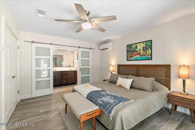 a bedroom with a bed couches and painting on the wall