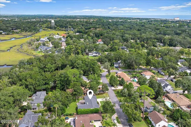 an aerial view of residential houses with outdoor space and trees