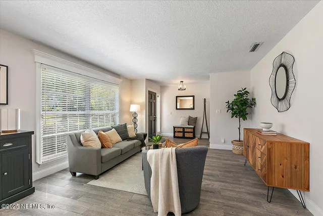 a living room with furniture a large window and a potted plant