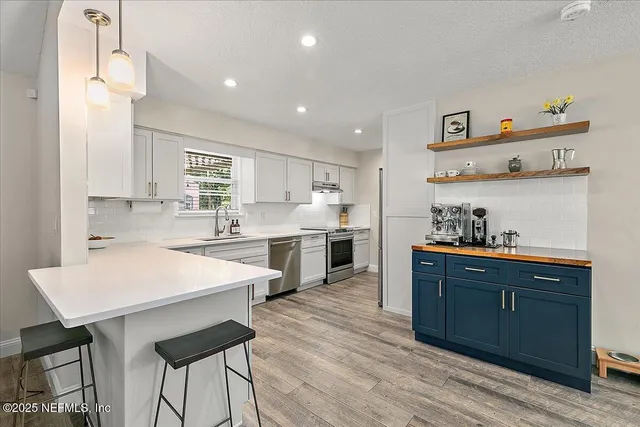 a kitchen with a sink a cabinets and wooden floor