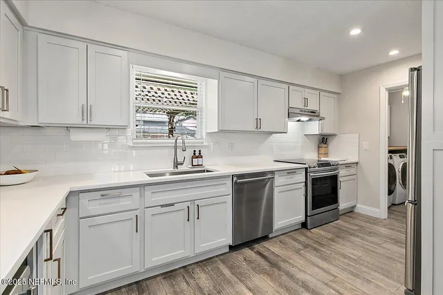 a kitchen with white cabinets and white appliances