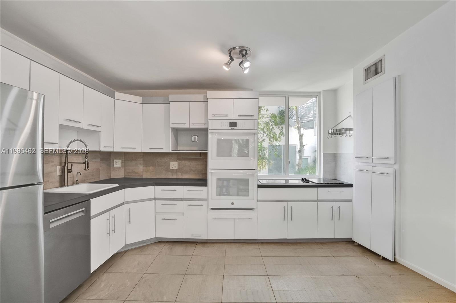 3126 Center Street, Unit 8 Coconut Grove, FL 33133 - Photo 13 of 50 a kitchen with white cabinets and white appliances
