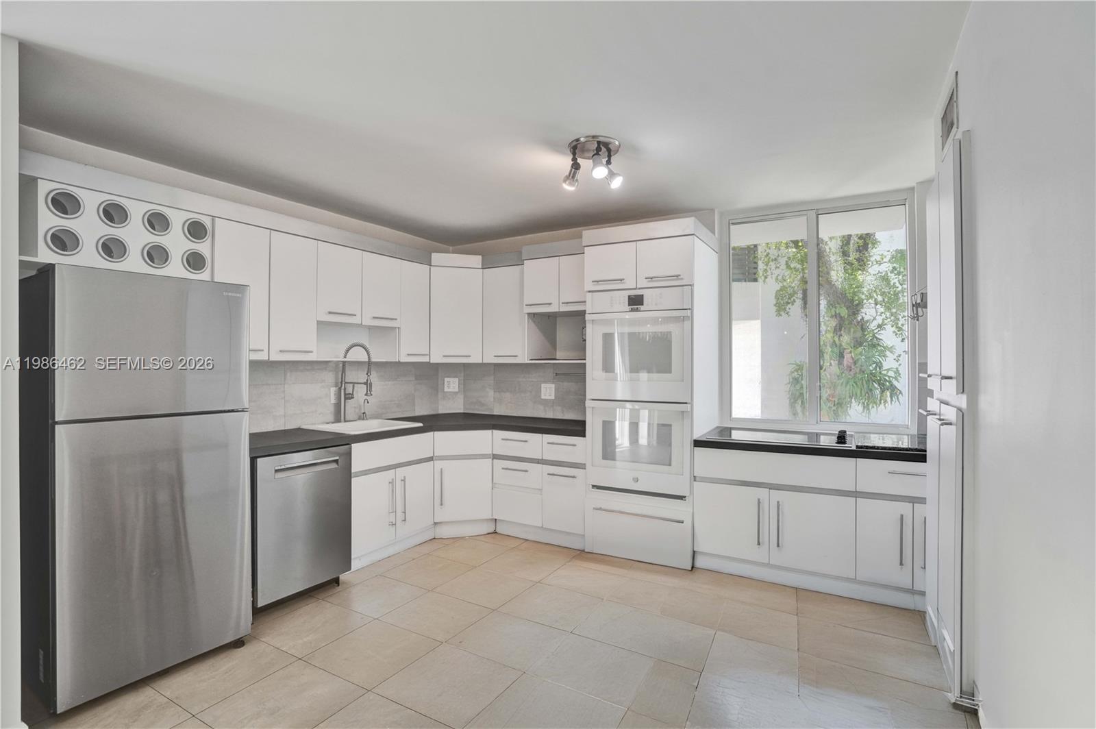 3126 Center Street, Unit 8 Coconut Grove, FL 33133 - Photo 14 of 50 a kitchen with white cabinets and white appliances