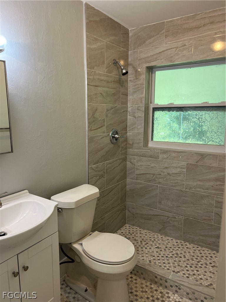 337 Tudor Drive, Unit R Cape Coral, FL 33904 - Photo 11 of 13 a white toilet sitting next to a bathroom sink