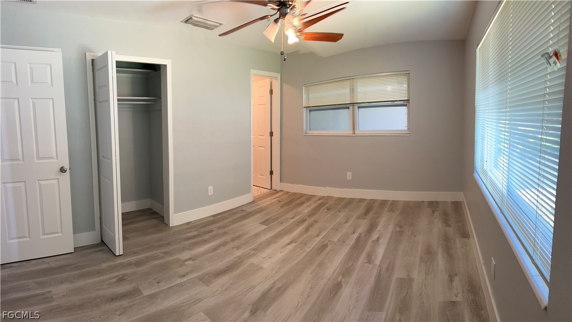 337 Tudor Drive, Unit R Cape Coral, FL 33904 - Photo 12 of 13 wooden floor in an empty room with a window