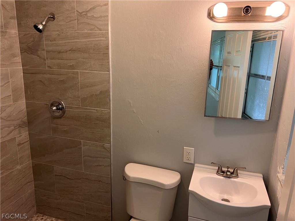 337 Tudor Drive, Unit R Cape Coral, FL 33904 - Photo 13 of 13 a bathroom with a sink a toilet and mirror