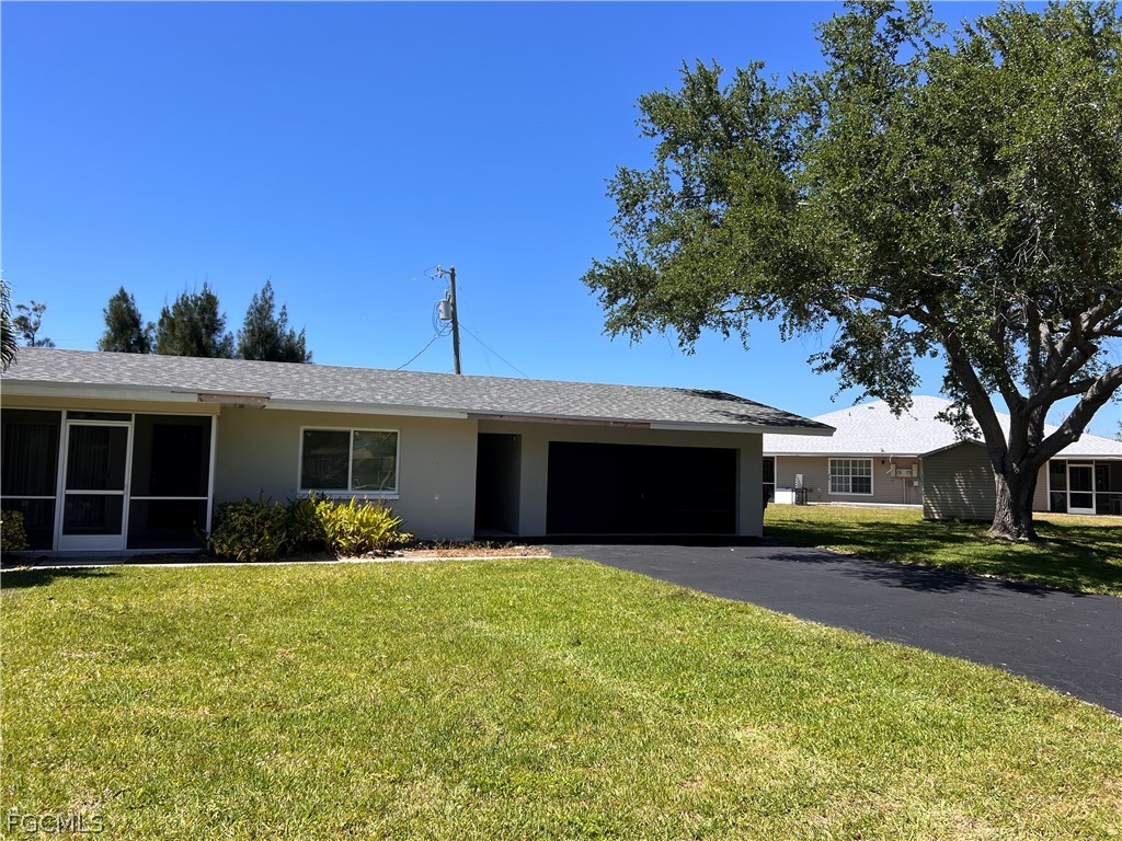 337 Tudor Drive, Unit R Cape Coral, FL 33904 - Photo 2 of 13 a front view of house with yard and green space