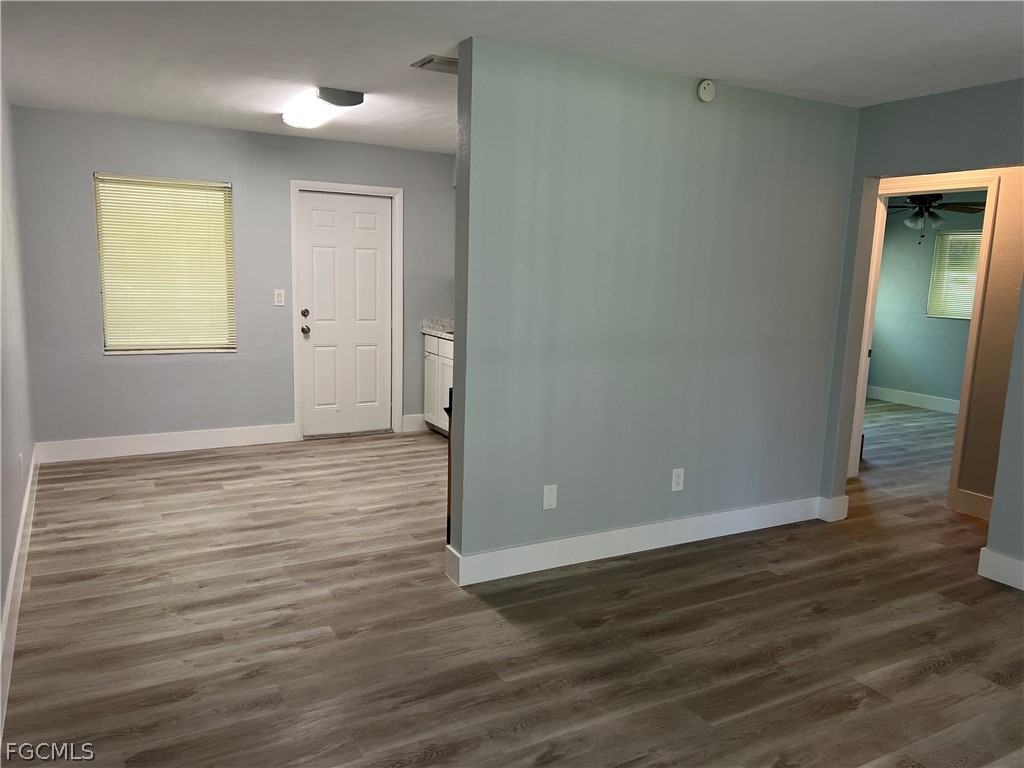337 Tudor Drive, Unit R Cape Coral, FL 33904 - Photo 3 of 13 a view of an empty room with wooden floor and a window