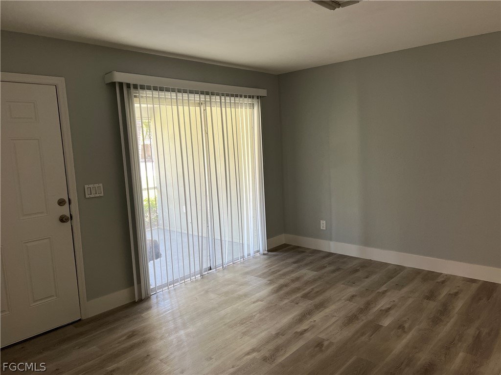337 Tudor Drive, Unit R Cape Coral, FL 33904 - Photo 4 of 13 an empty room with wooden floor and windows