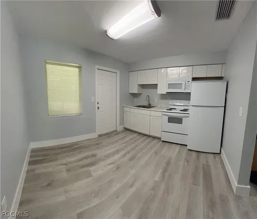 a room with window and white cabinets