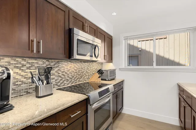 a kitchen with stainless steel appliances granite countertop a sink stove and microwave