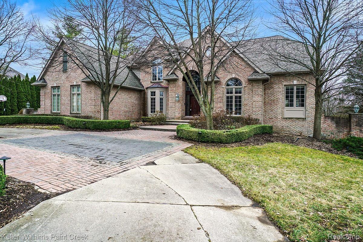Formal gardens and circular drive accent the curb appeal of this beautiful brick home
