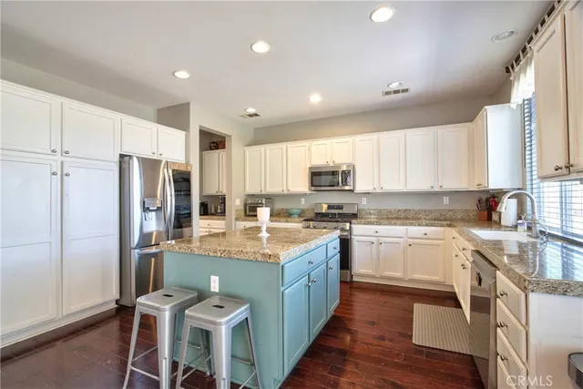 a large kitchen with stainless steel appliances lots of counter space and wooden floor