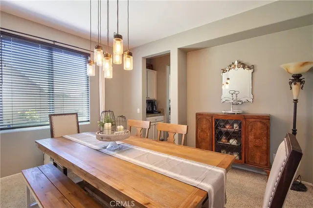 a dining room with wooden floor a chandelier a wooden table and chairs