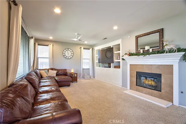 a living room with furniture a fireplace and a flat screen tv