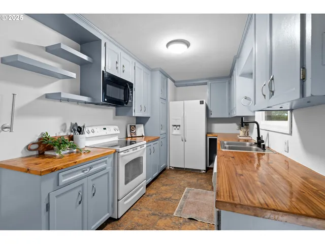 a kitchen that has a lot of cabinets a sink and appliances