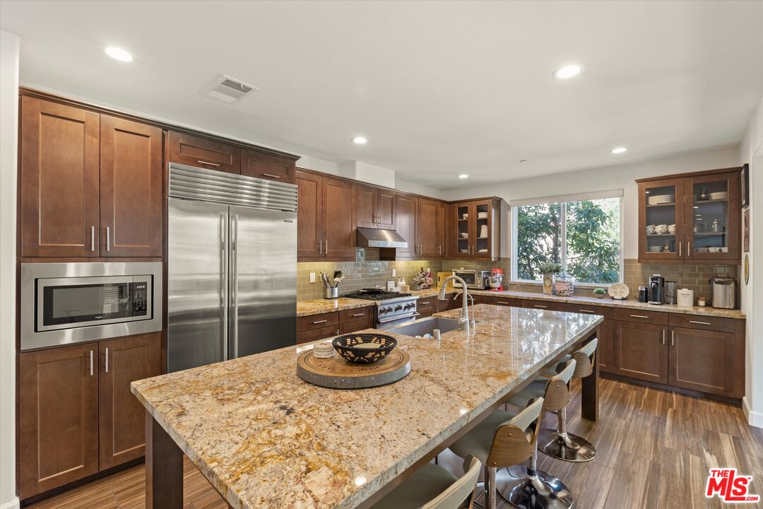 12883 West Runway Road, Unit 1 Playa Vista, CA 90094 - Photo 8 of 36 a kitchen with kitchen island granite countertop a sink appliances and wooden floor