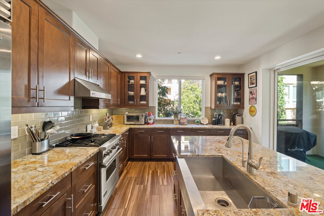 12883 West Runway Road, Unit 1 Playa Vista, CA 90094 - Photo 10 of 36 a kitchen with granite countertop a stove a sink and a refrigerator