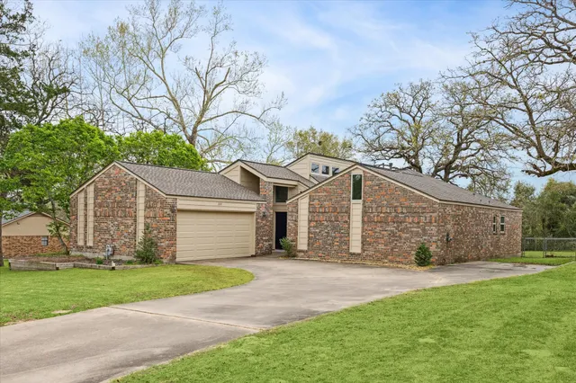 front view of a house with a yard and an trees