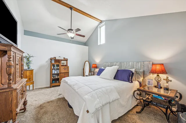 a bedroom with a bed a flat screen tv and a bookshelf