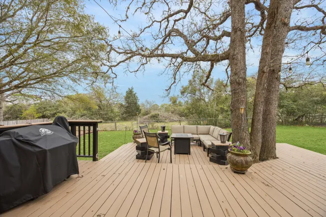 a view of a deck with furniture and garden