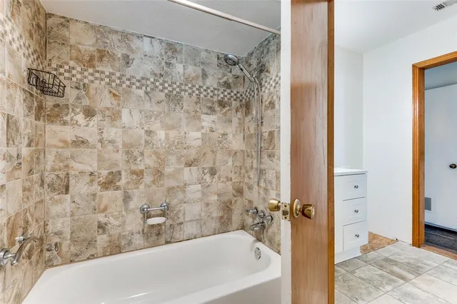 a bathroom with a bathtub and shower