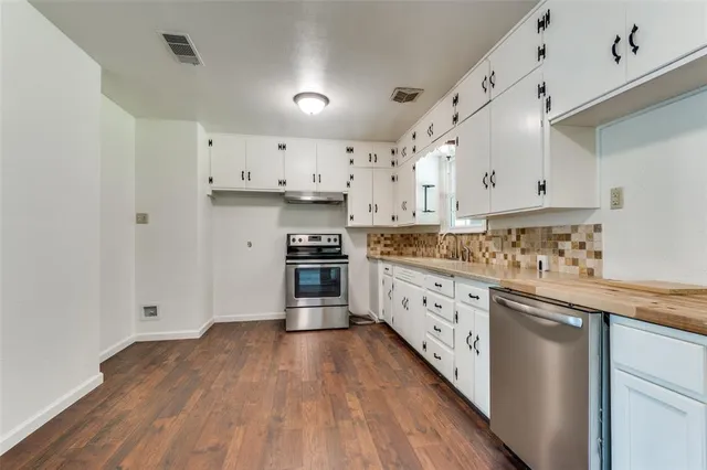 a kitchen with granite countertop a sink and cabinets with wooden floors