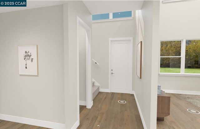 a view of a hallway with wooden floor and a bathroom
