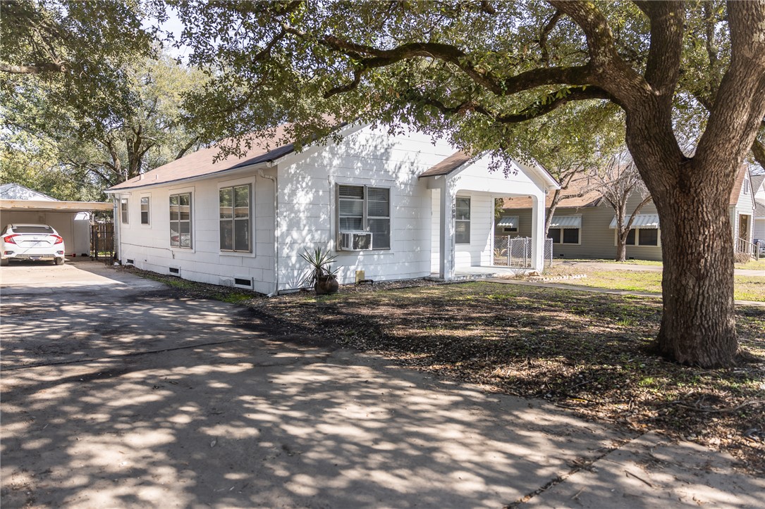 a front view of a house with a tree