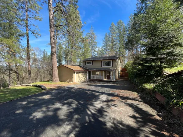 a front view of a house with a yard and trees