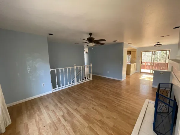 a view of a hallway with wooden floor and a chandelier