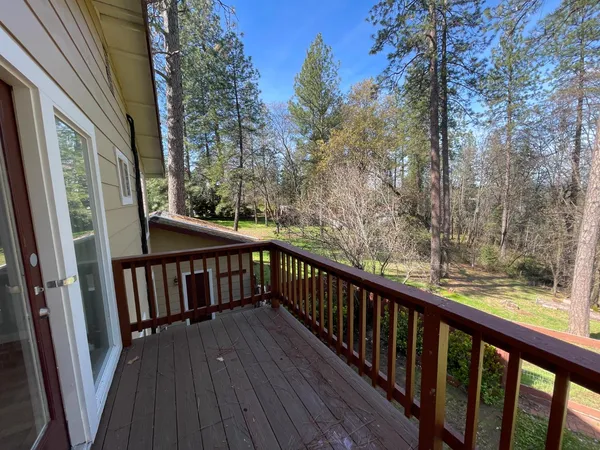 a view of balcony with wooden floor and fence